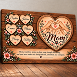 Personalized wooden plaque for Mom featuring carved heart-shaped name panels, floral accents, two hands forming a heart, and a sentimental message, displayed on a wooden floor against a light wall.