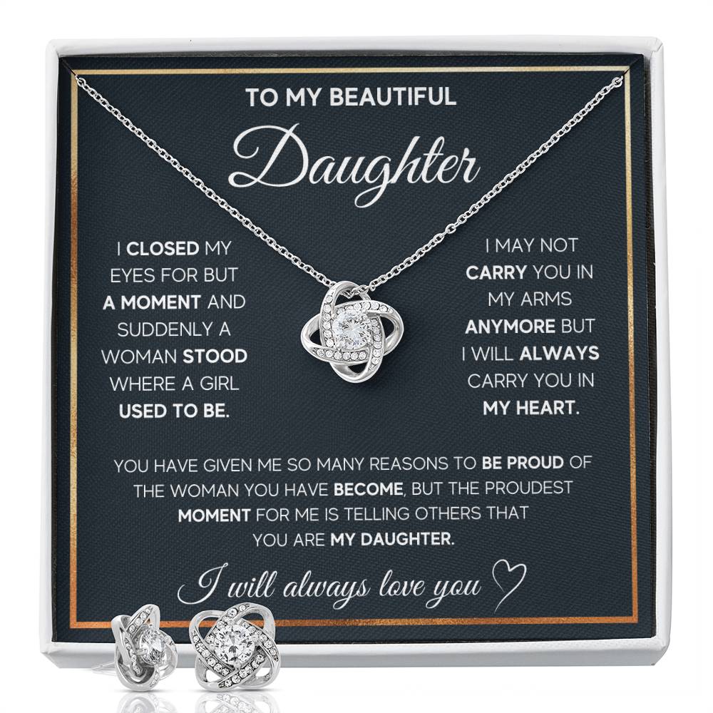 The photo displays a close-up view of a delicate pendant with intricate twists symbolizing eternal love, adorned with sparkling cubic zirconia crystals. The pendant hangs elegantly from a fine silver chain.