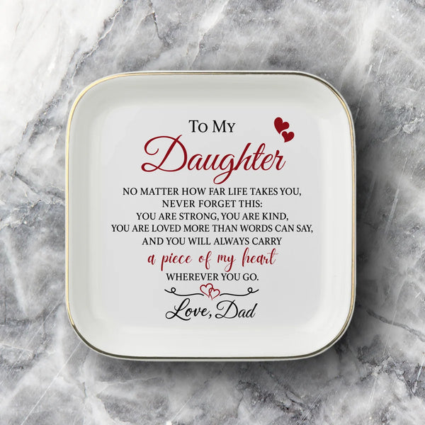 A square white ceramic plate with rounded corners, featuring black printed text and a heart graphic that reads 'difference maker' on a gray and white marble background.